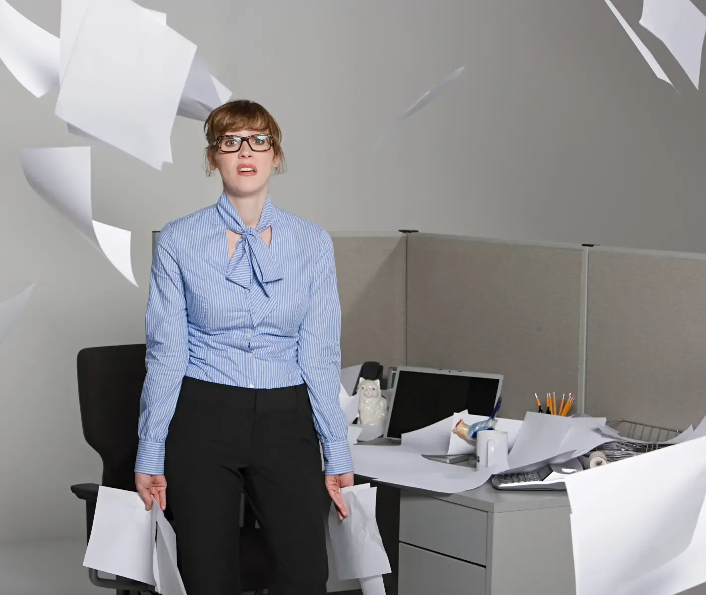 Frau im Büro wirft mit Papier